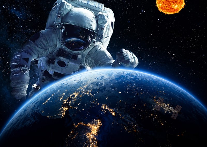 Photo composite of an astronaut floating above Earth at night